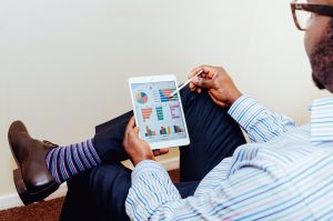 Person Checking Investments on Tablet